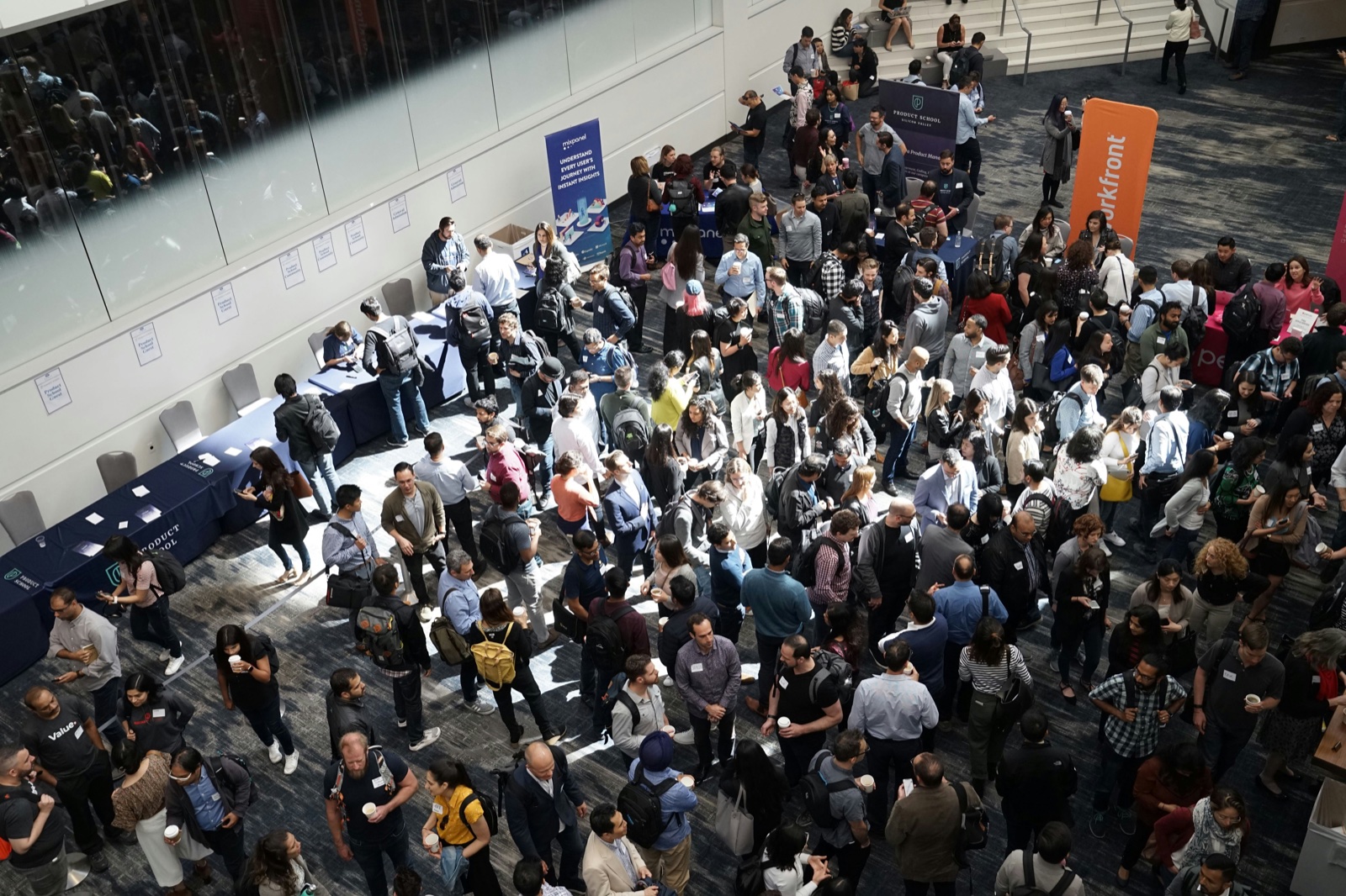 A crowd of professionals networking at a large industry event